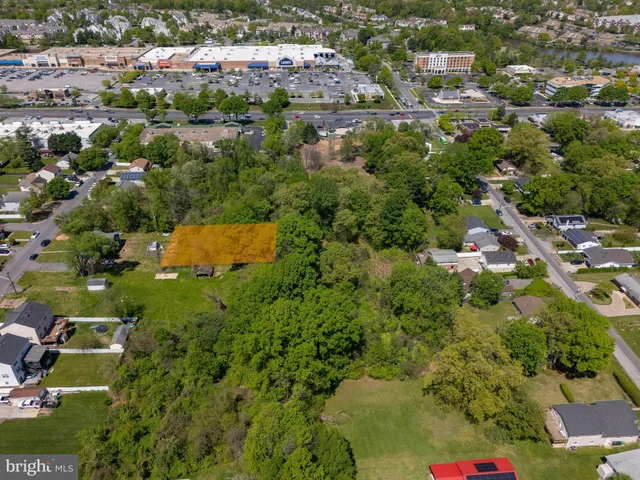 an aerial view of residential house with outdoor space and trees all around