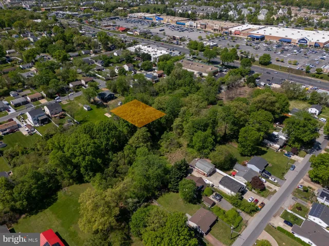 an aerial view of residential houses with outdoor space and trees