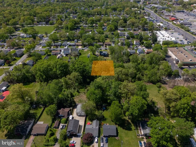 an aerial view of residential houses with outdoor space and trees