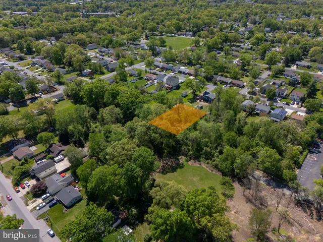 an aerial view of residential houses with outdoor space and trees