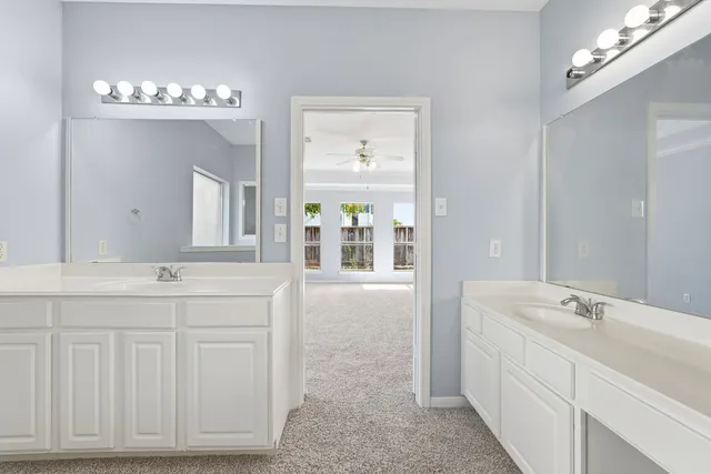 a bathroom with a double vanity sink mirror and bathtub
