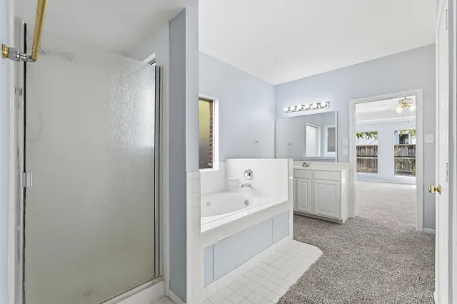 a bathroom with a tub sink and mirror