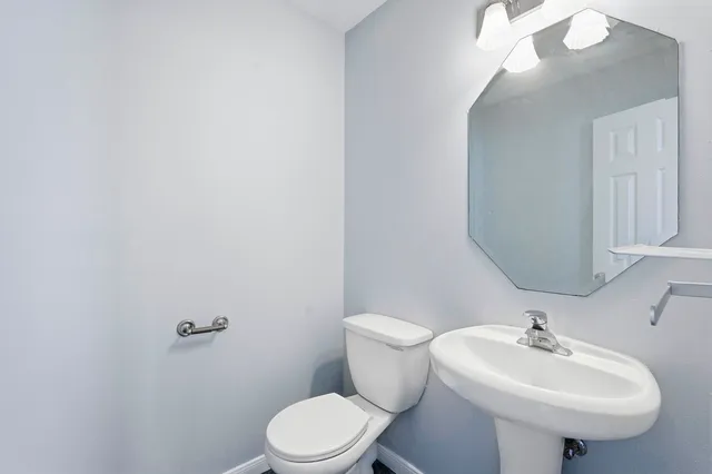 a bathroom with a sink a toilet and mirror