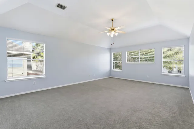 an empty room with a window and a ceiling fan