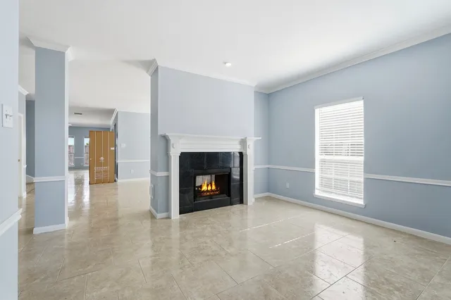 a view of an empty room with a fireplace and a window