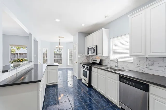 a large kitchen with stainless steel appliances lots of counter space and a sink
