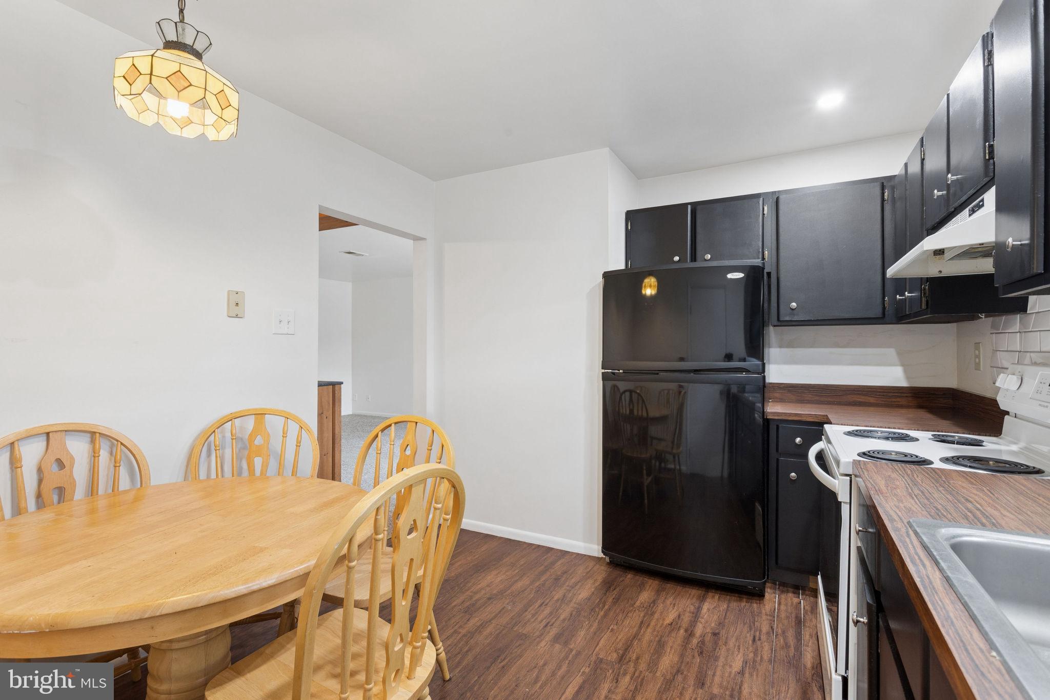 1475 Mt Holly Road, Unit R3 Edgewater Park, NJ 08010 - Photo 10 of 19 a kitchen with stainless steel appliances granite countertop a refrigerator a stove a sink dishwasher a dining table and chairs with wooden floor