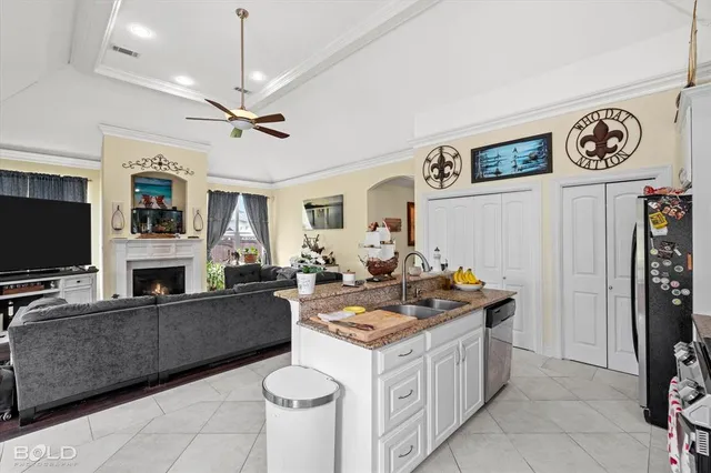 a view of living room kitchen with stainless steel appliances granite countertop furniture and a flat screen tv