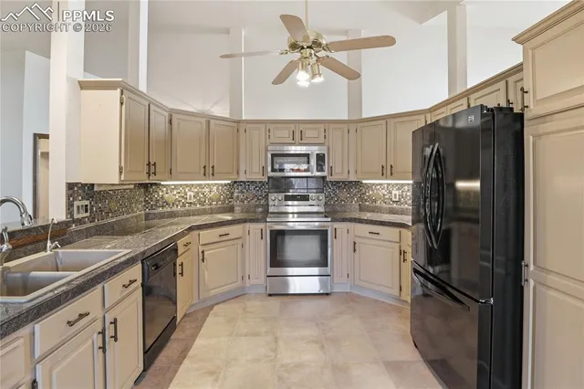 a kitchen with stainless steel appliances granite countertop a refrigerator stove and sink