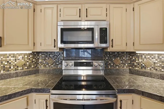 a kitchen with granite countertop a stove microwave and cabinets