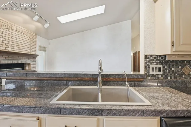 a kitchen with a sink and a wooden floor