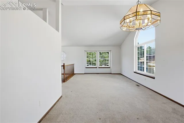 an empty room with windows and chandelier