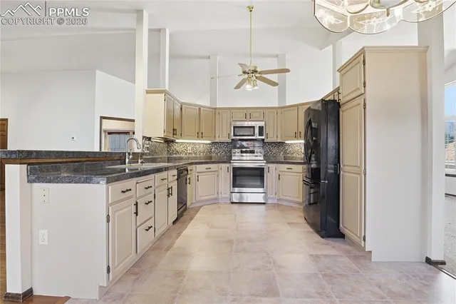 a large kitchen with cabinets a sink stainless steel appliances and a window