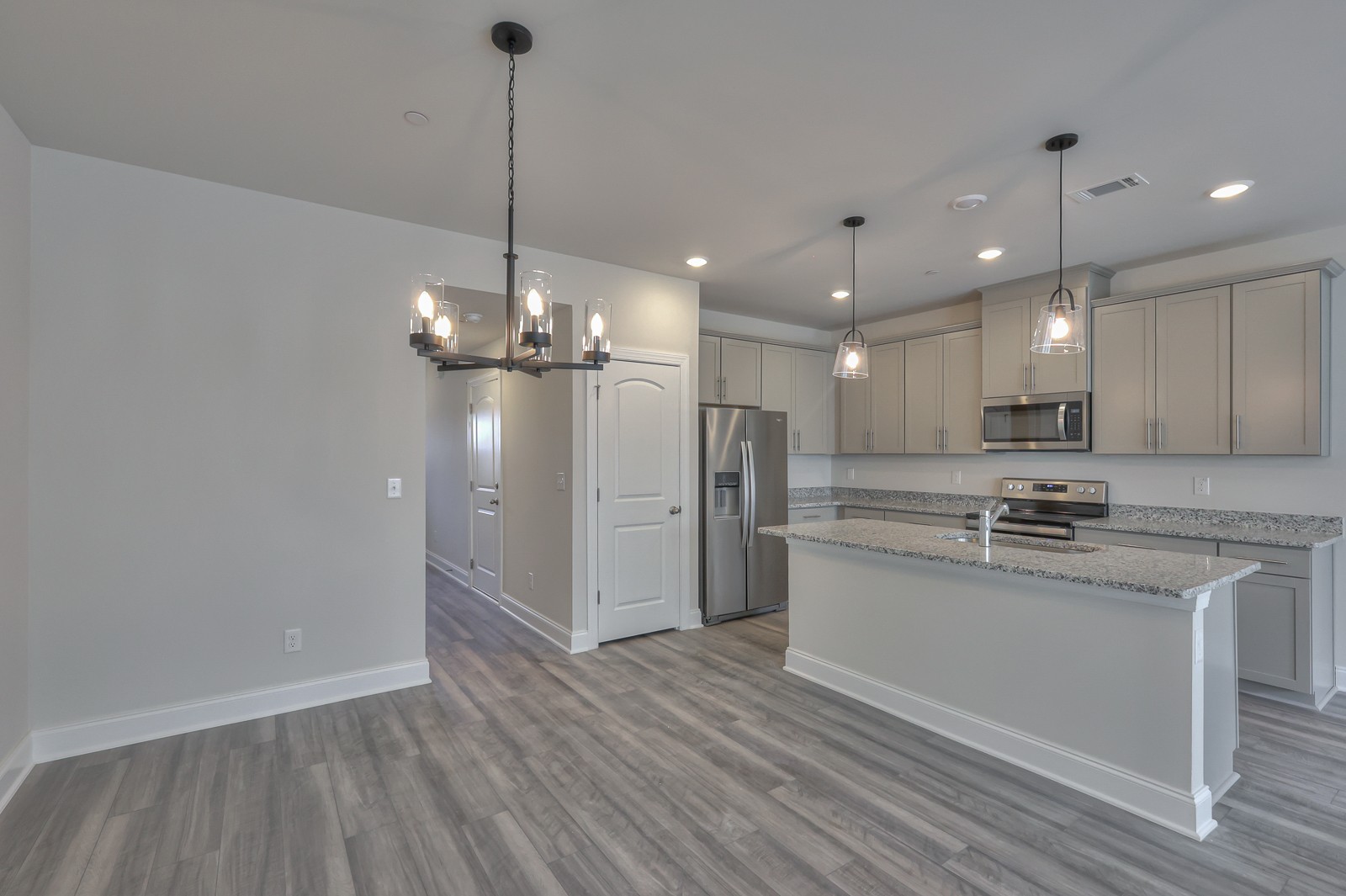 204 Douglas Bend Road, Unit 902 Gallatin, TN 37066 - Photo 7 of 32 a kitchen with kitchen island white cabinets and stainless steel appliances