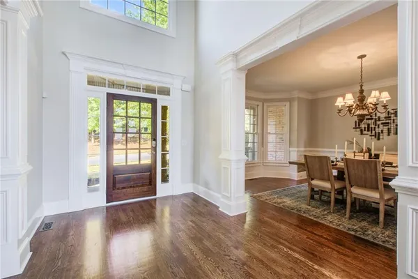a view of a dining room and livingroom with furniture wooden floor a chandelier