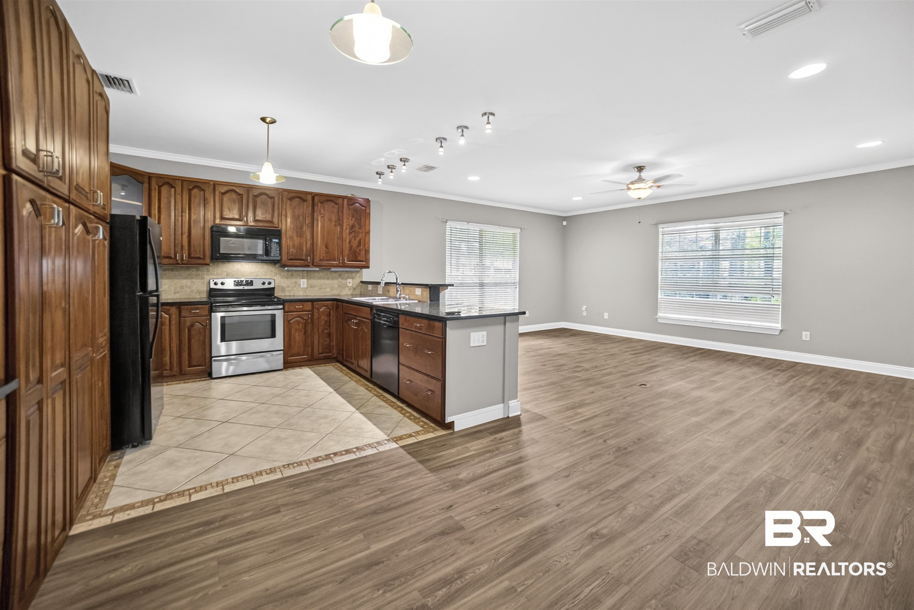5913 Antoine Road Mobile, AL 36693 - Photo 5 of 33 Open-concept kitchen and living area featuring wood-finish flooring, a ceiling fan, and large windows