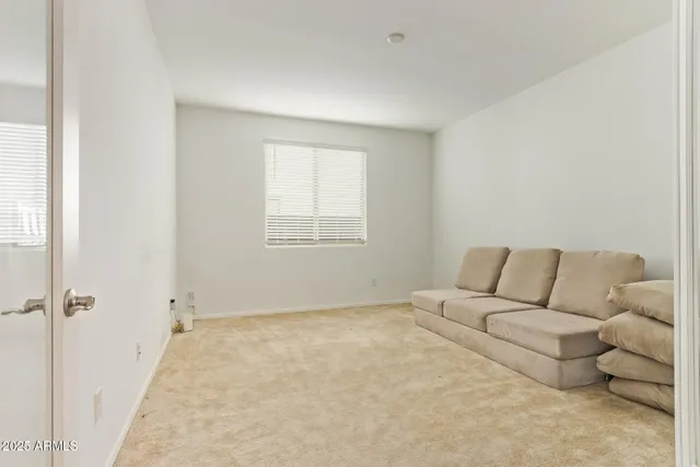 a living room with furniture and a view of kitchen