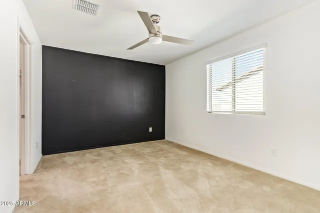 an empty room with a flat screen tv and white walls