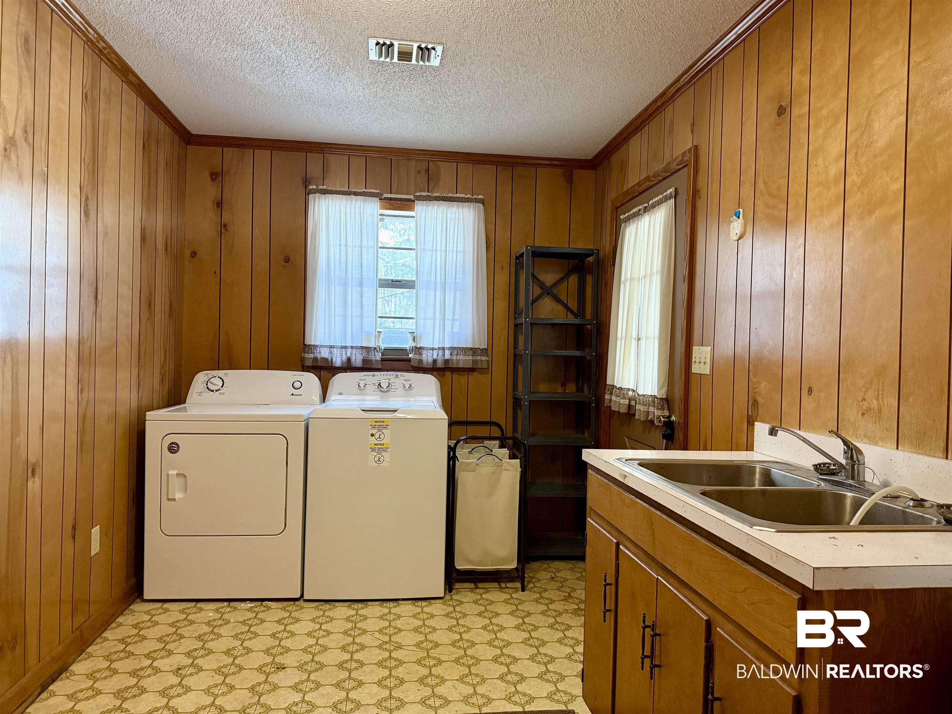 98 Evans Avenue Brewton, AL 36426 - Photo 13 of 18 Laundry area with crown molding, light floors, wooden walls, and washer and dryer