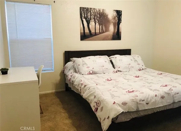 a bedroom with a bed and a painting on the wall