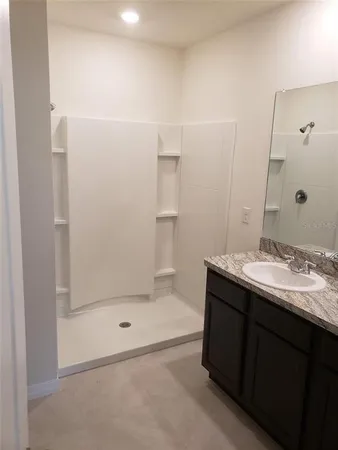 a bathroom with a granite countertop toilet a sink and a bathtub
