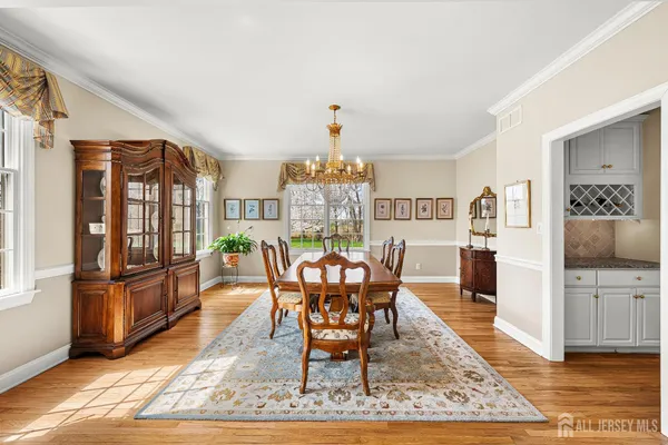 a dining room with furniture a chandelier and wooden floor