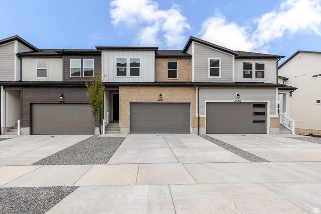 Modern home featuring concrete driveway and an attached garage
