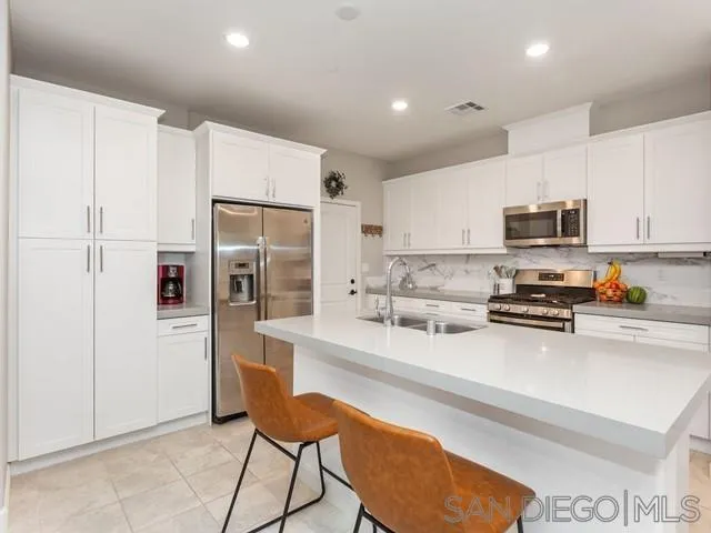 1087 Delpy View Point Vista, CA 92084 - Photo 8 of 32 a kitchen with stainless steel appliances a refrigerator and a stove top oven