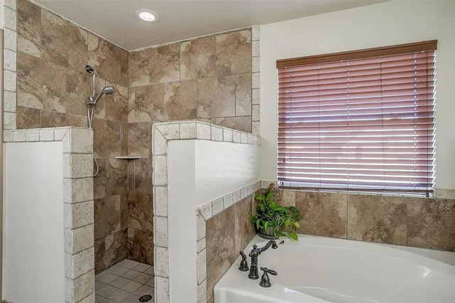 a bathroom with a bathtub and shower