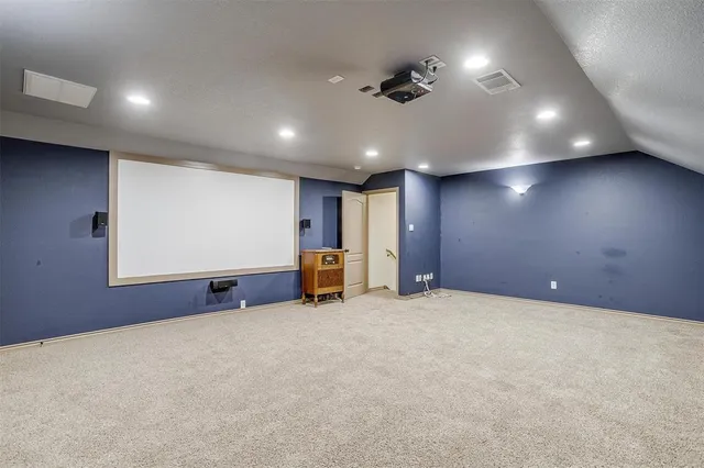 an empty room with projector and furniture