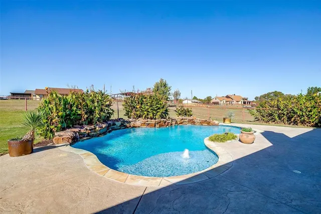 a view of a swimming pool with a yard and outdoor seating