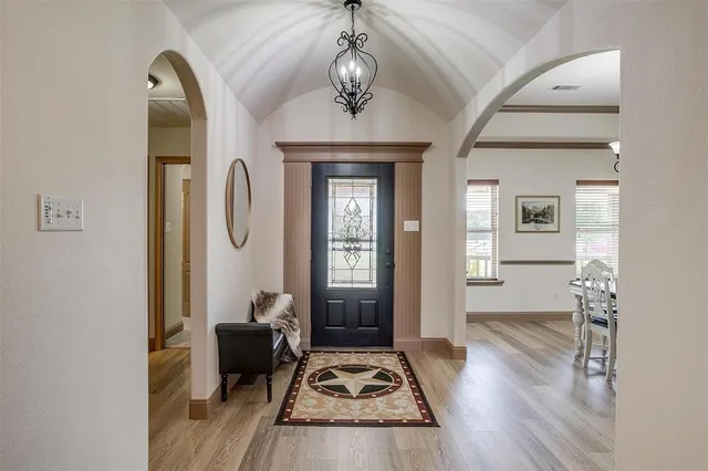 a view of a hallway with wooden floor and a livingroom