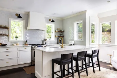 a kitchen with a dining table chairs cabinets and window