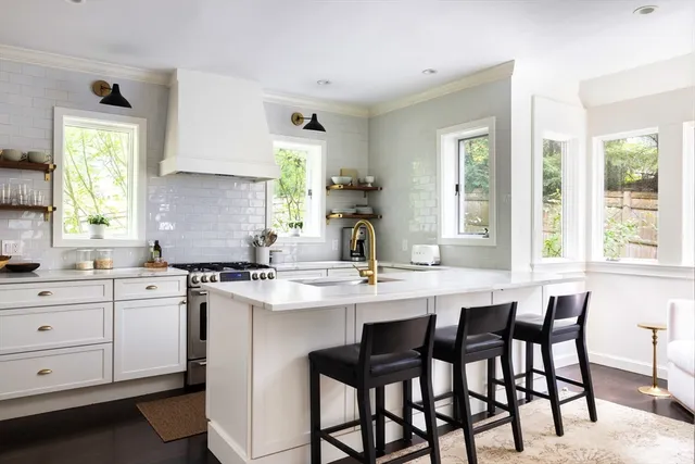 a kitchen with a dining table chairs cabinets and window