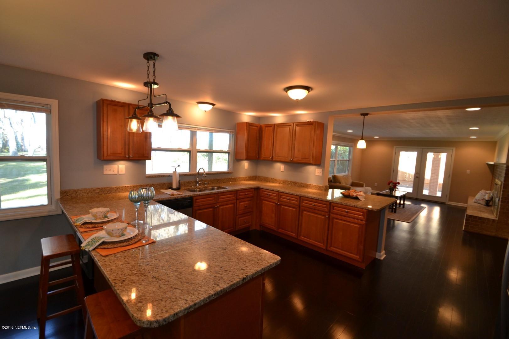 76 Harmony Hall Road Middleburg, FL 32068 - Photo 37 of 67 a kitchen with stainless steel appliances granite countertop a sink dishwasher a stove a dining table and chairs with wooden floor