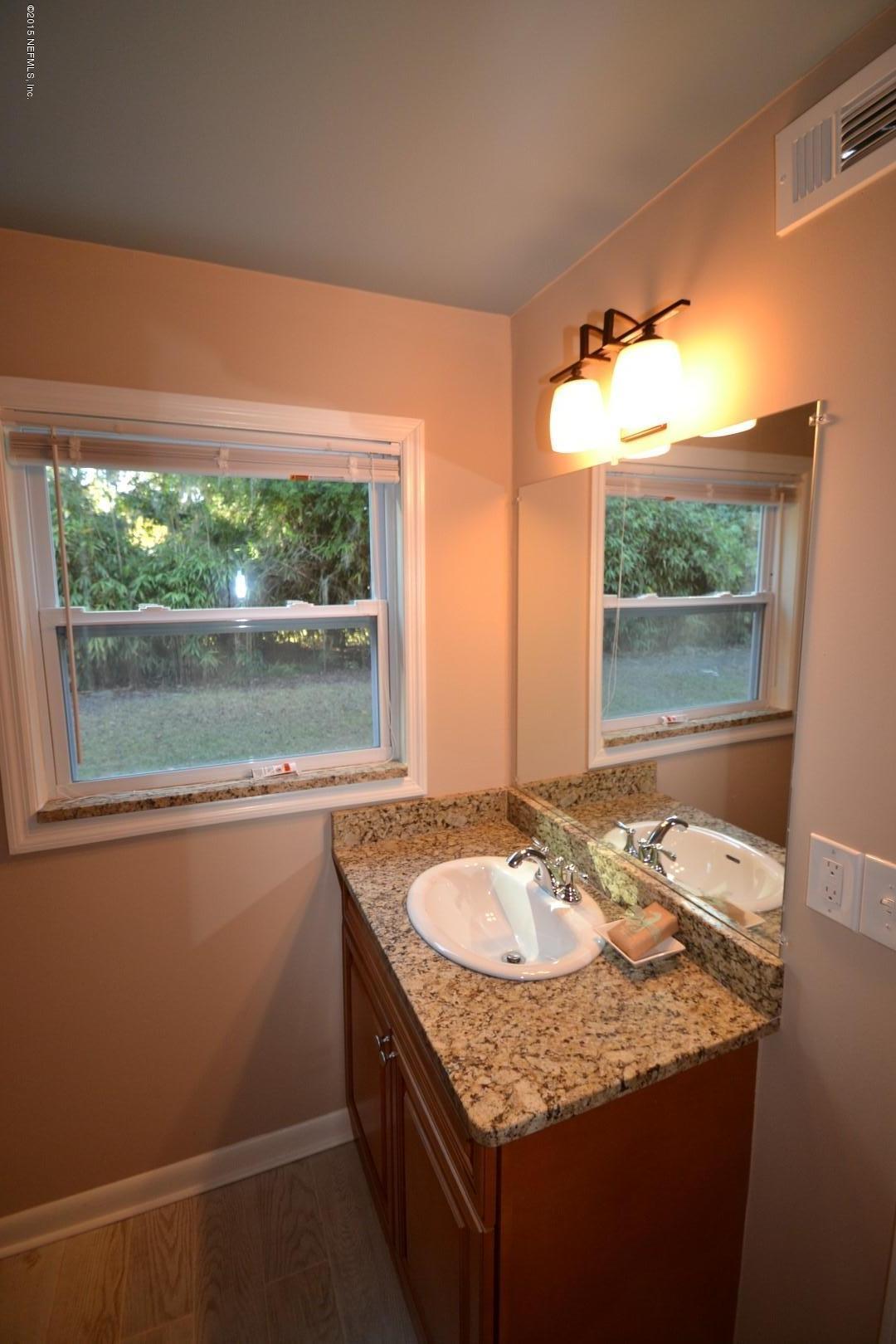 76 Harmony Hall Road Middleburg, FL 32068 - Photo 40 of 67 a bathroom with a granite countertop sink a mirror and a bathtub