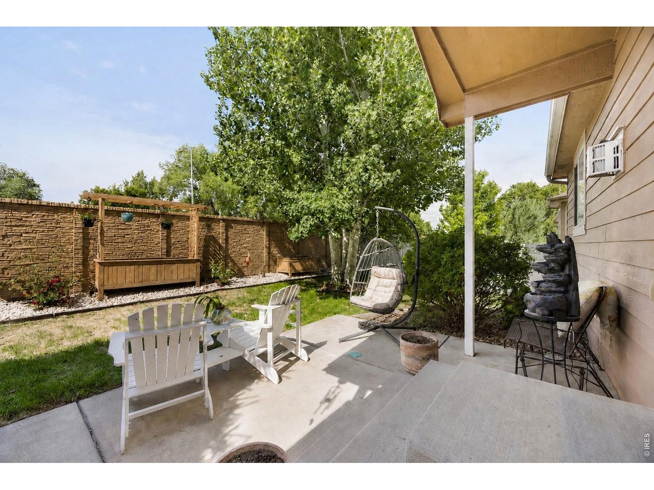 148 Beacon Way Windsor, CO 80550 - Photo 31 of 36 Backyard retreat featuring a covered patio, mature aspen trees, raised garden beds, and privacy fencing.