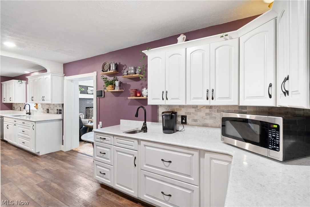 443 Merriman Road Akron, OH 44303 - Photo 17 of 44 Kitchen featuring white shaker-style cabinetry, light-toned countertops, a light-toned tile backsplash, and wood-finish flooring
