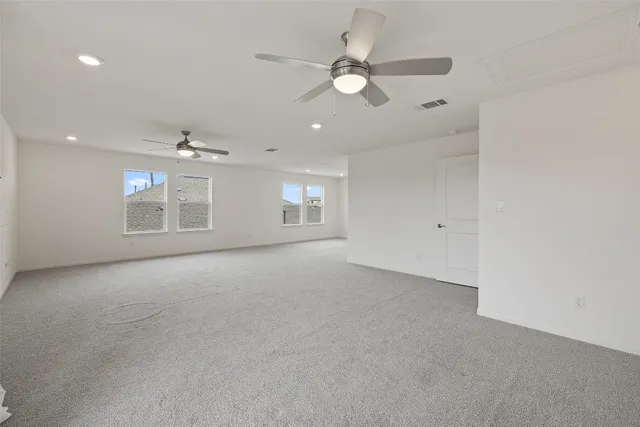 wooden floor in an empty room with a ceiling fan