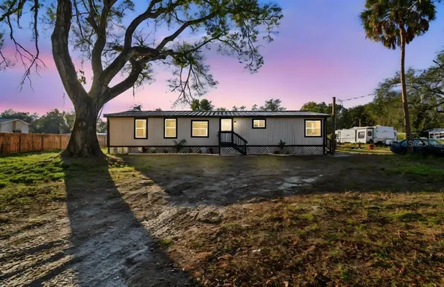 a view of a house with backyard and trees