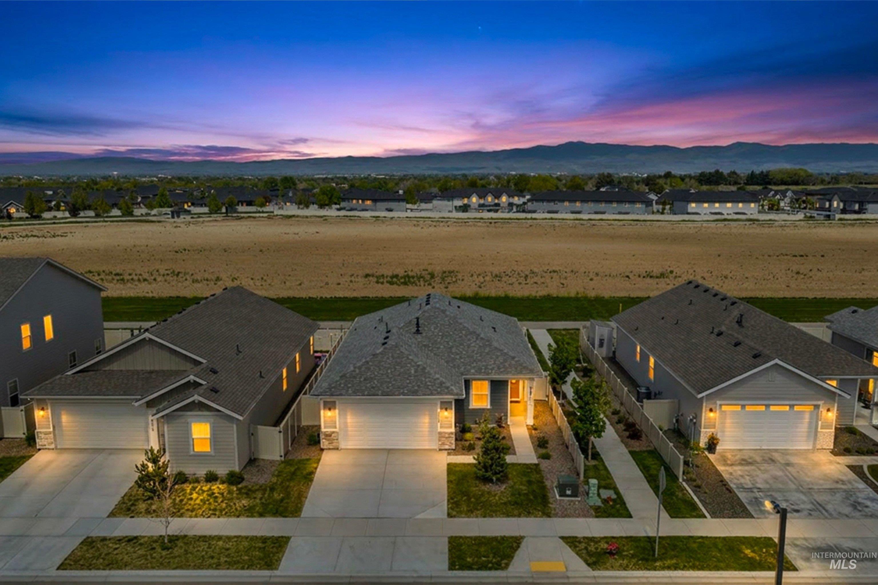 Contemporary single-story residence featuring light gray siding and a dark gray shingle roof