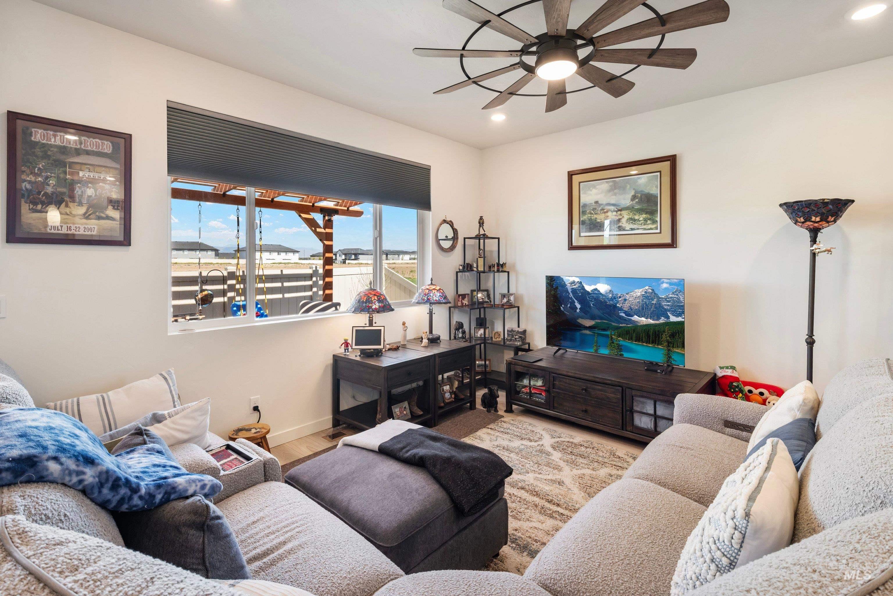 4232 South Graycliff Way Meridian, ID 83642 - Photo 11 of 34 Spacious living area featuring a large window with horizontal blinds, overhead ceiling fan, recessed lighting, and light wood-finish flooring