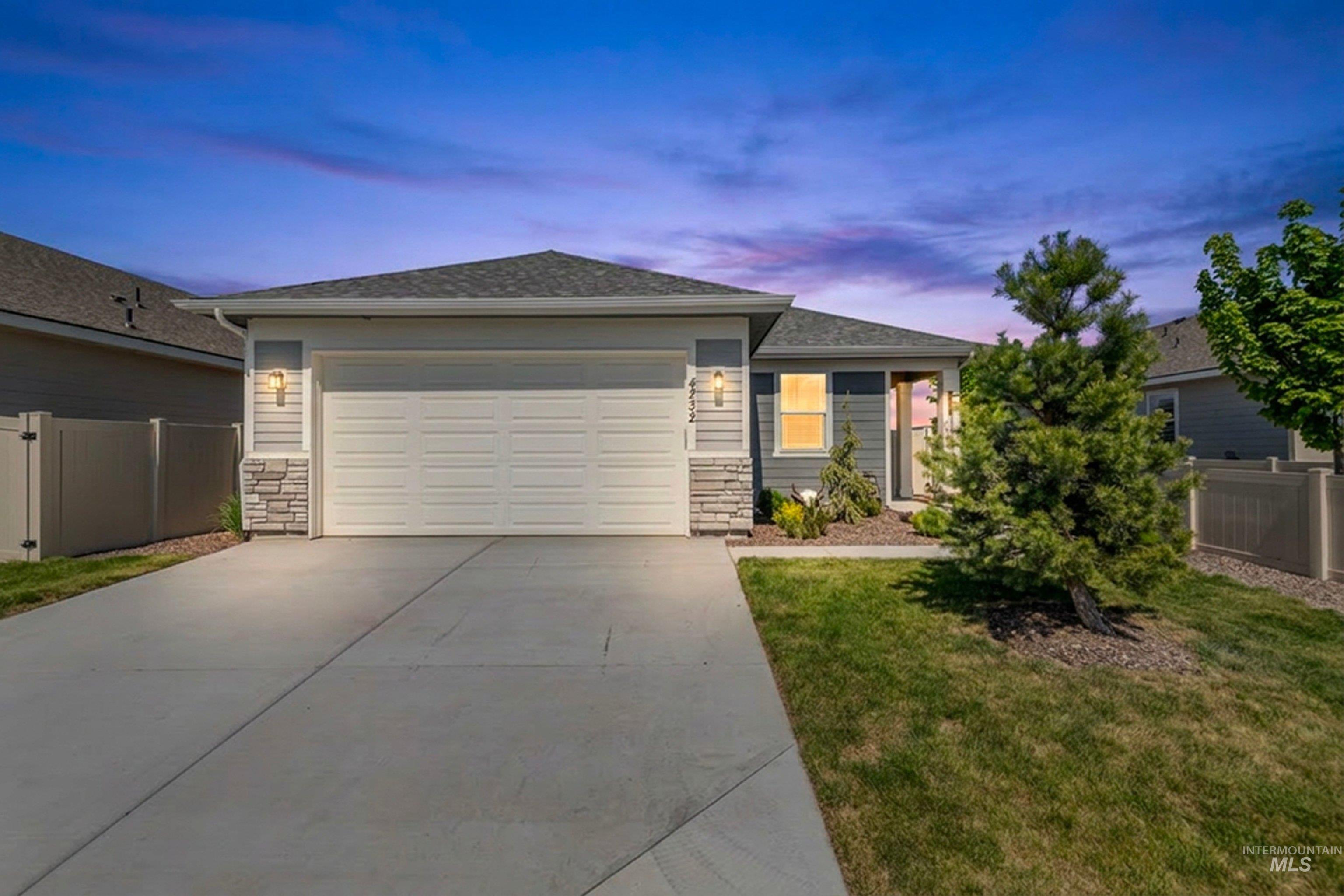 4232 South Graycliff Way Meridian, ID 83642 - Photo 3 of 34 Contemporary ranch-style exterior featuring a prominent two-car garage, stone accents, horizontal siding, and a concrete driveway