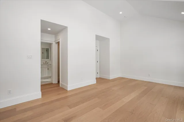 a view of an empty room with wooden floor and closet