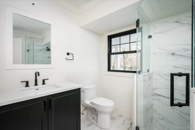 a bathroom with a toilet a sink a window and mirror