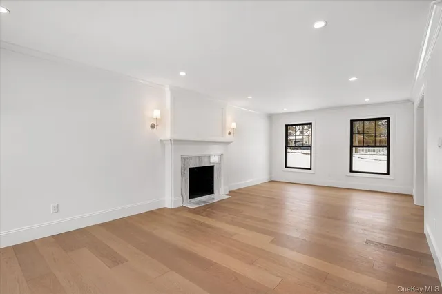 a view of empty room with wooden floor and fireplace