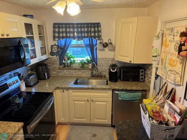 a kitchen with stainless steel appliances a stove a sink and a microwave