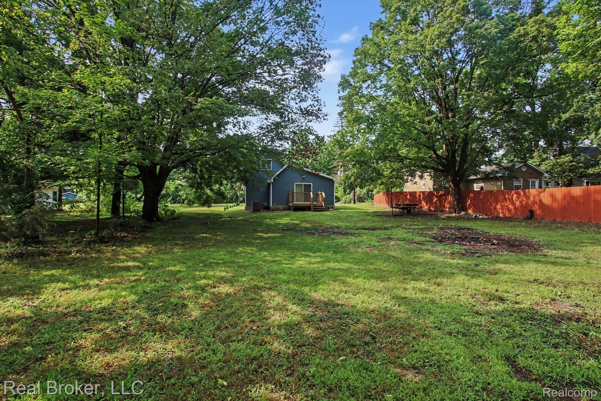 217 East Edgar Bergen Boulevard Decatur, MI 49045 - Photo 15 of 16 Expansive grassy yard with mature trees and a wooden privacy fence