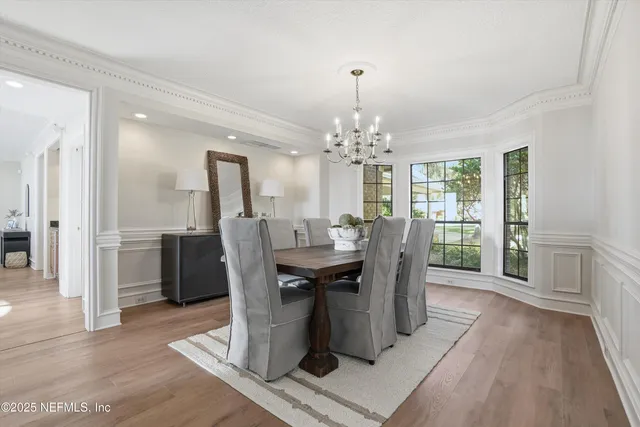 a living room with furniture large windows and a view of bedroom