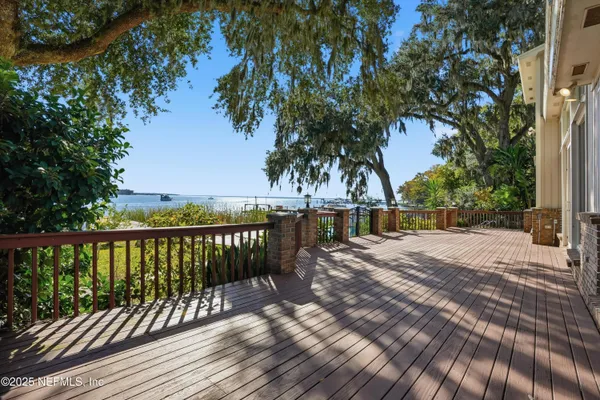 a living room with furniture large windows and a view of bedroom